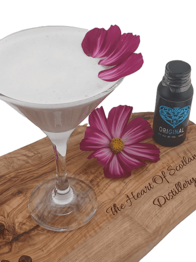 Violette Gin Fizz made with Heart of Scotland Gin in a martini glass, garnished with an edible violet.