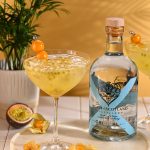 Passion Fruit Fizz cocktail with Heart of Scotland Original Gin, fresh passion fruit, ice and golden berry garnish beside the bottle.